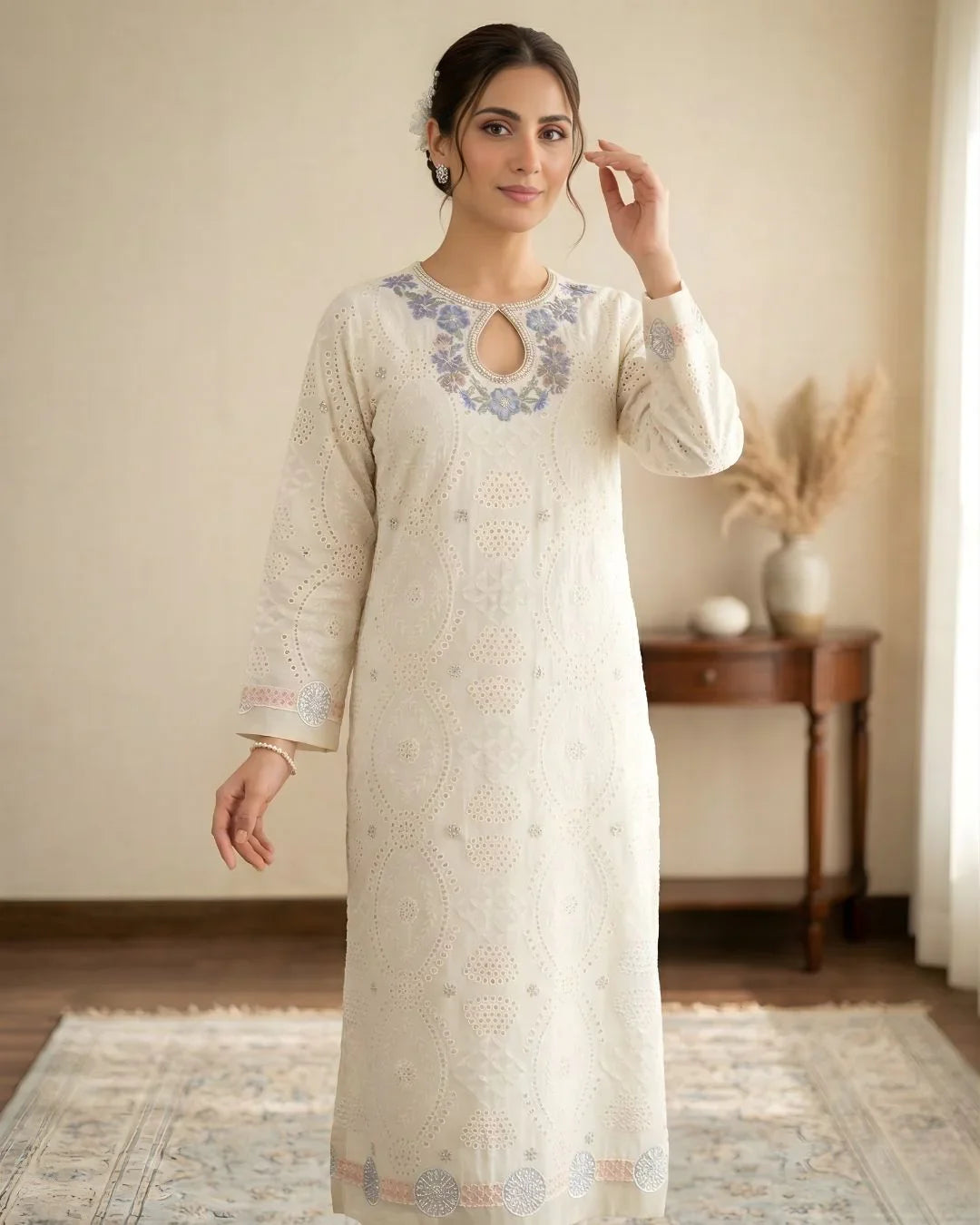 Woman wearing an ivory embroidered kurta with floral neckline in a cozy indoor setting