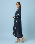 Woman wearing navy blue embroidered kurta with long sleeves and side slit, paired with heels