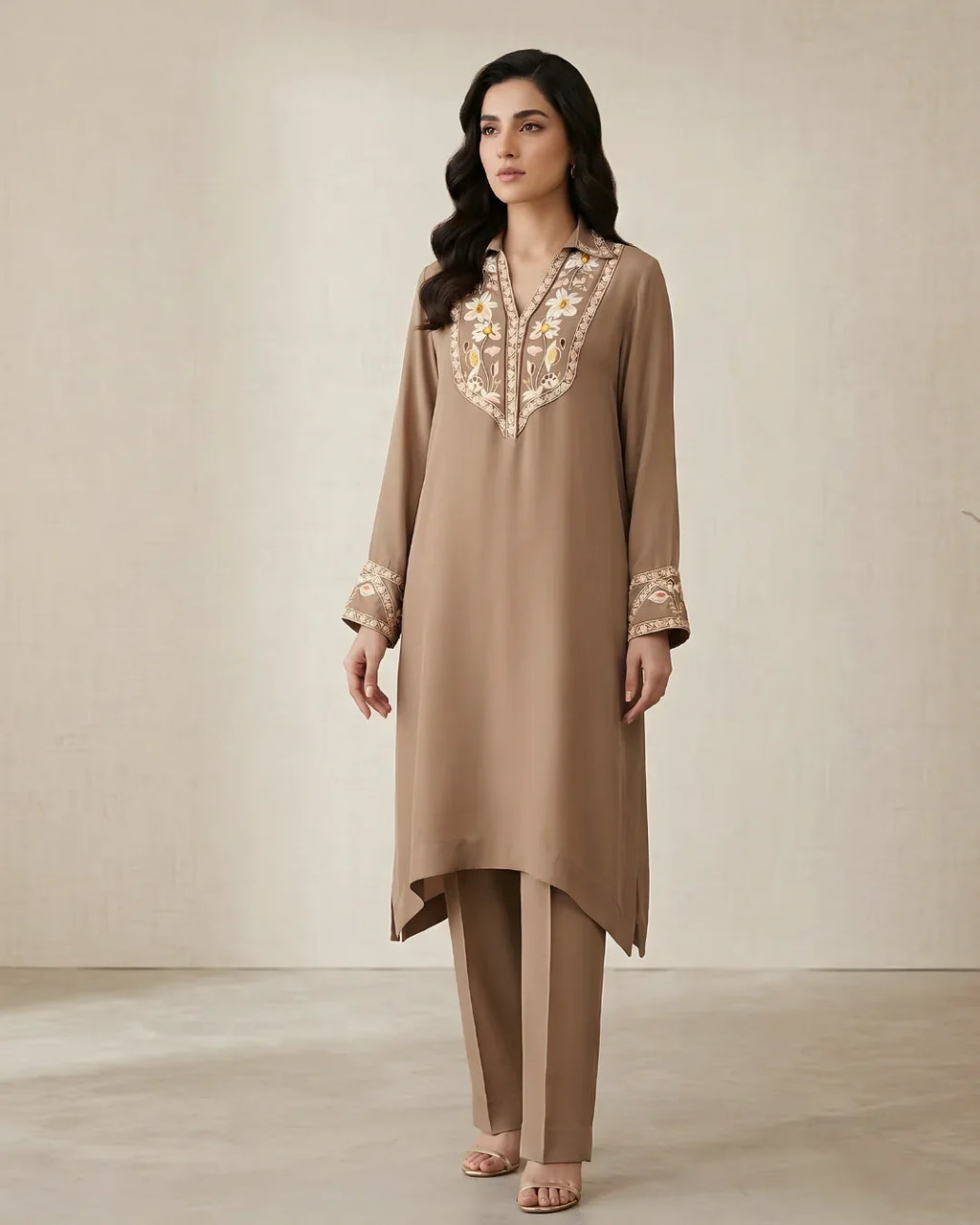 Woman wearing a beige embroidered kurta set with floral detailing and straight pants