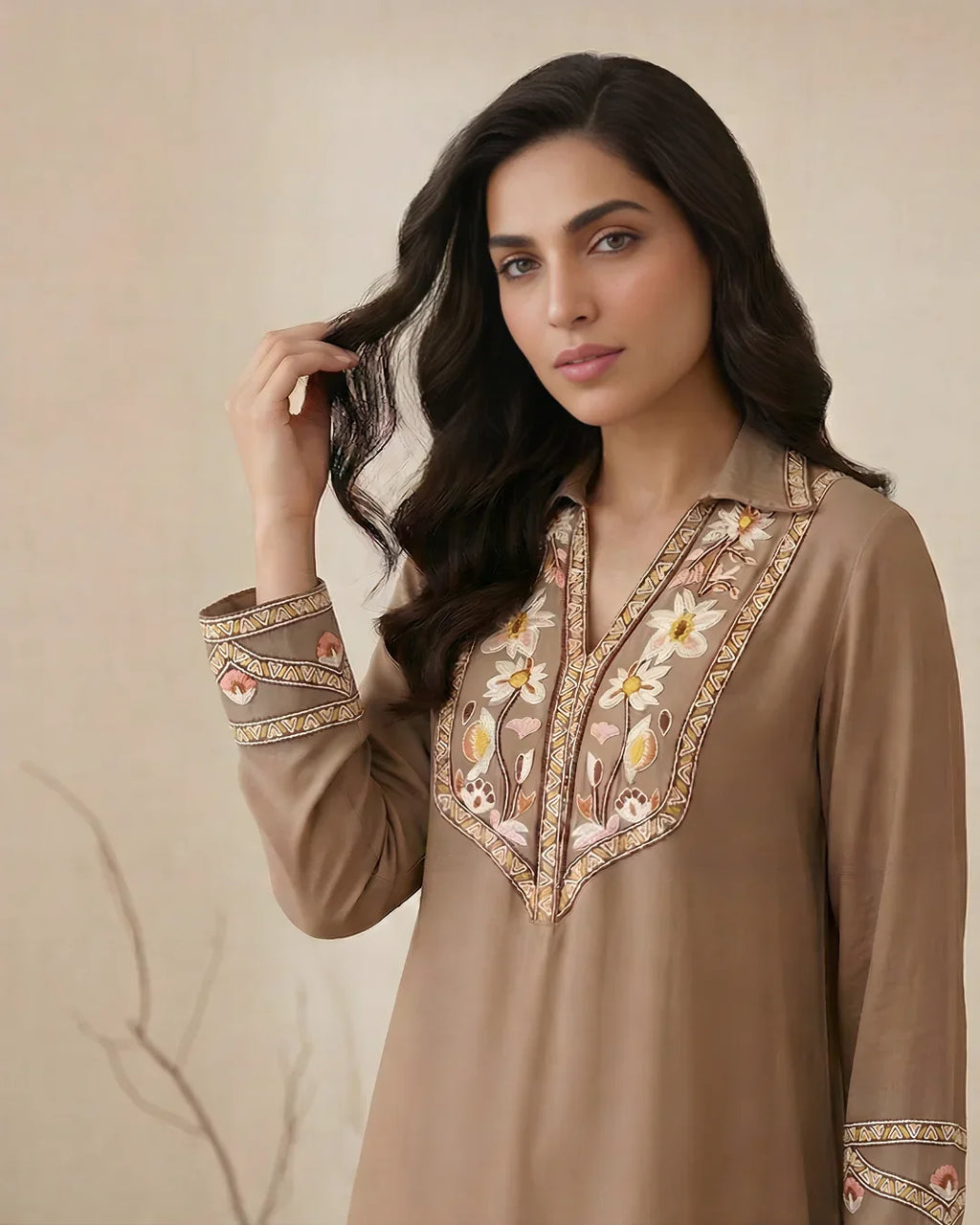 Woman wearing brown embroidered kurta with floral detailing and traditional Pakistani design