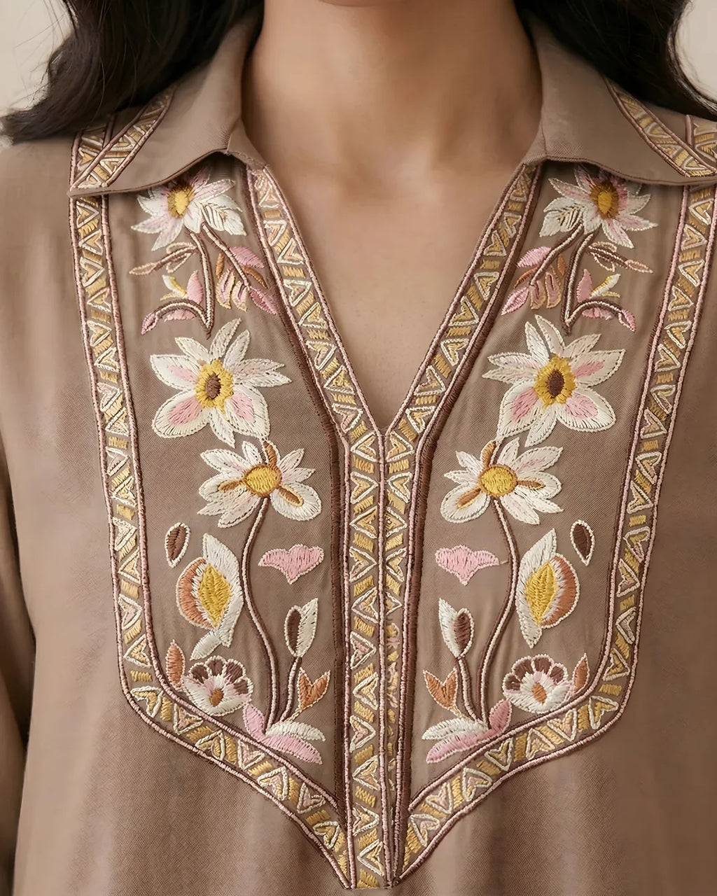 Beige kurta with floral embroidery, V-neck, and intricate threadwork accents.