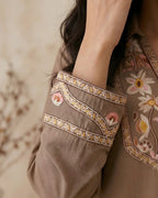 Close-up of brown long sleeve kurta with pastel floral embroidery and decorative stitching